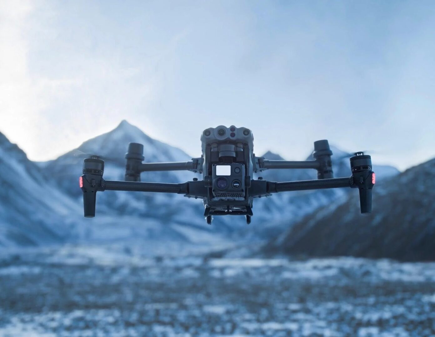 A black and silver camera flying over a mountain.