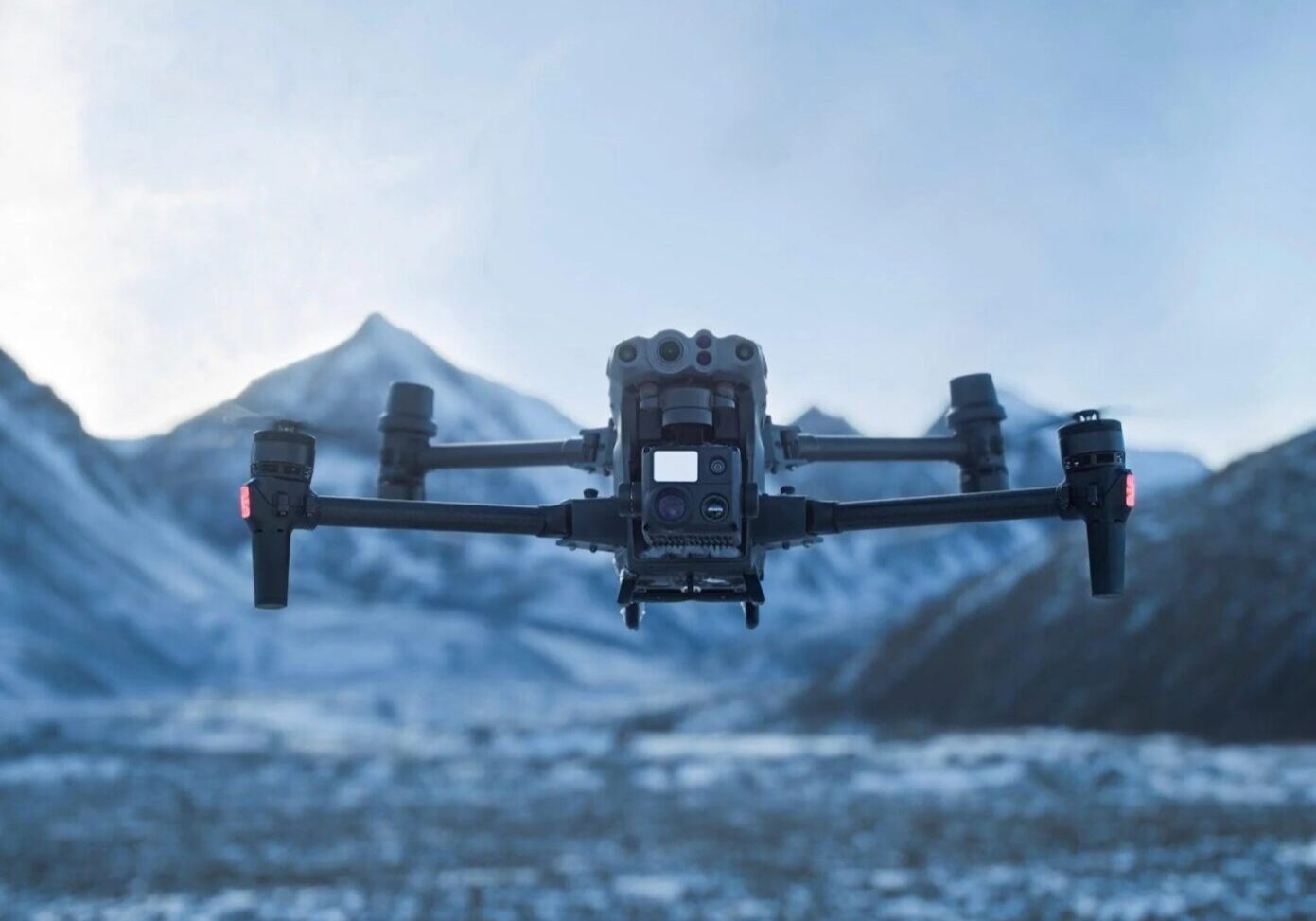 A black and silver camera flying over a mountain.